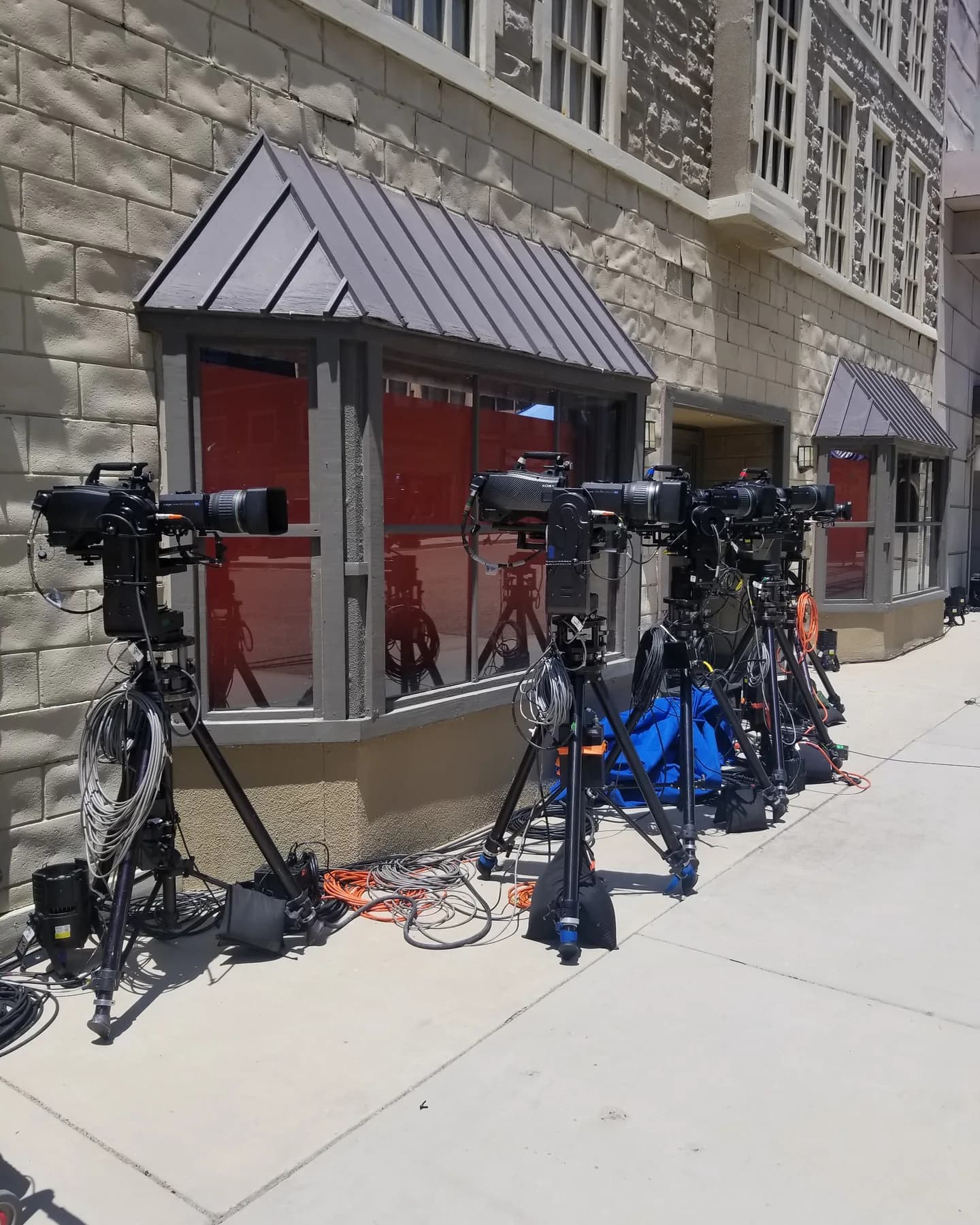 A row of Talon remote heads on tripods along a studio backlot street