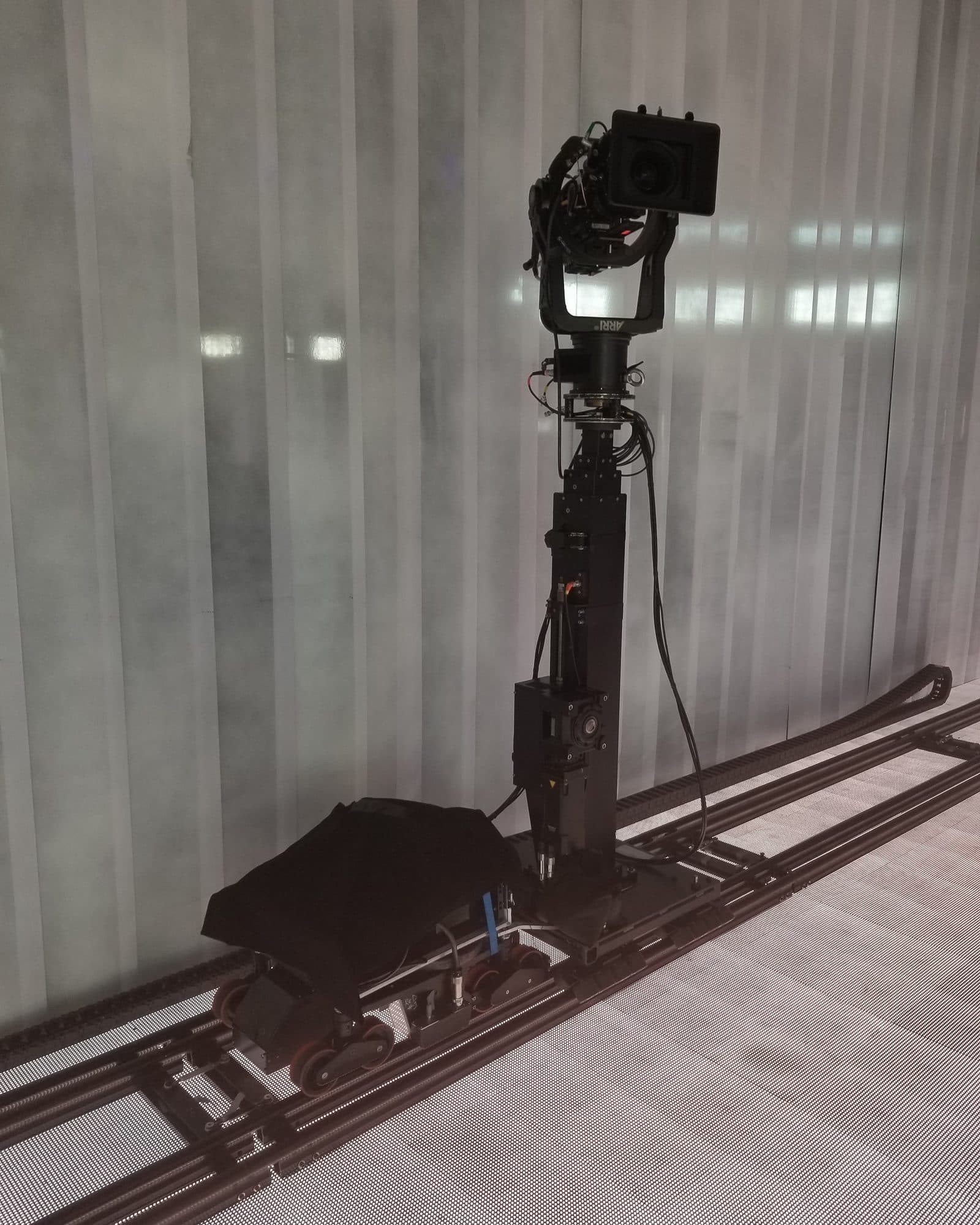 MAT Towercam 410 mounted on a track dolly with the column retracted, carrying a remote head and camera