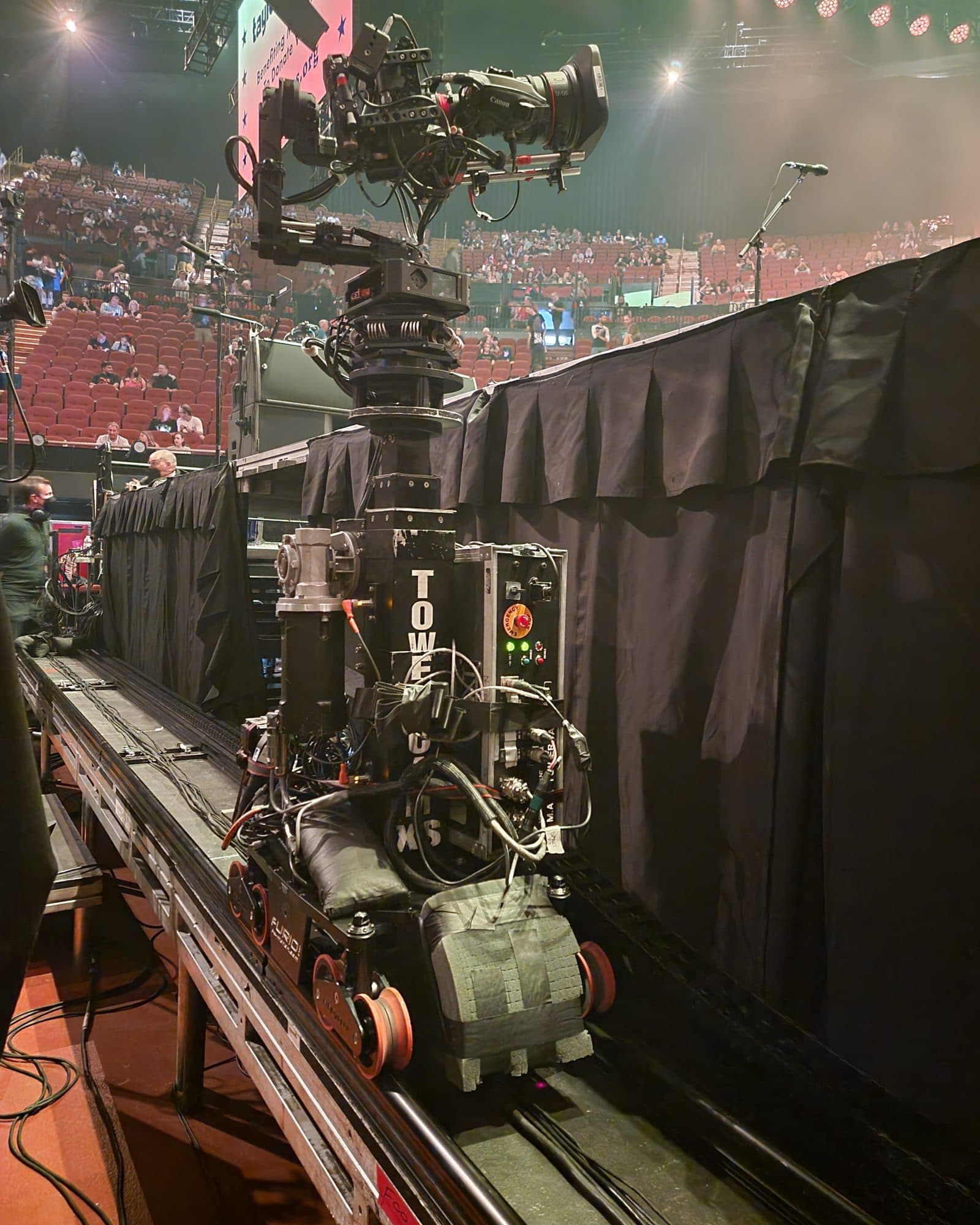MAT Towercam XS mounted on track at an arena, carrying a broadcast camera above the seating