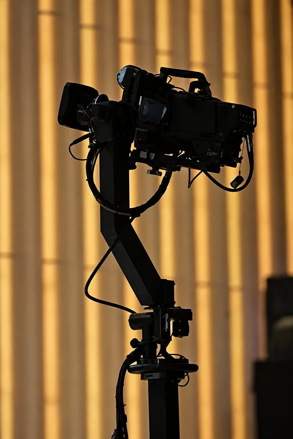 Stanton Triangle remote head silhouetted against a gold-lit set
