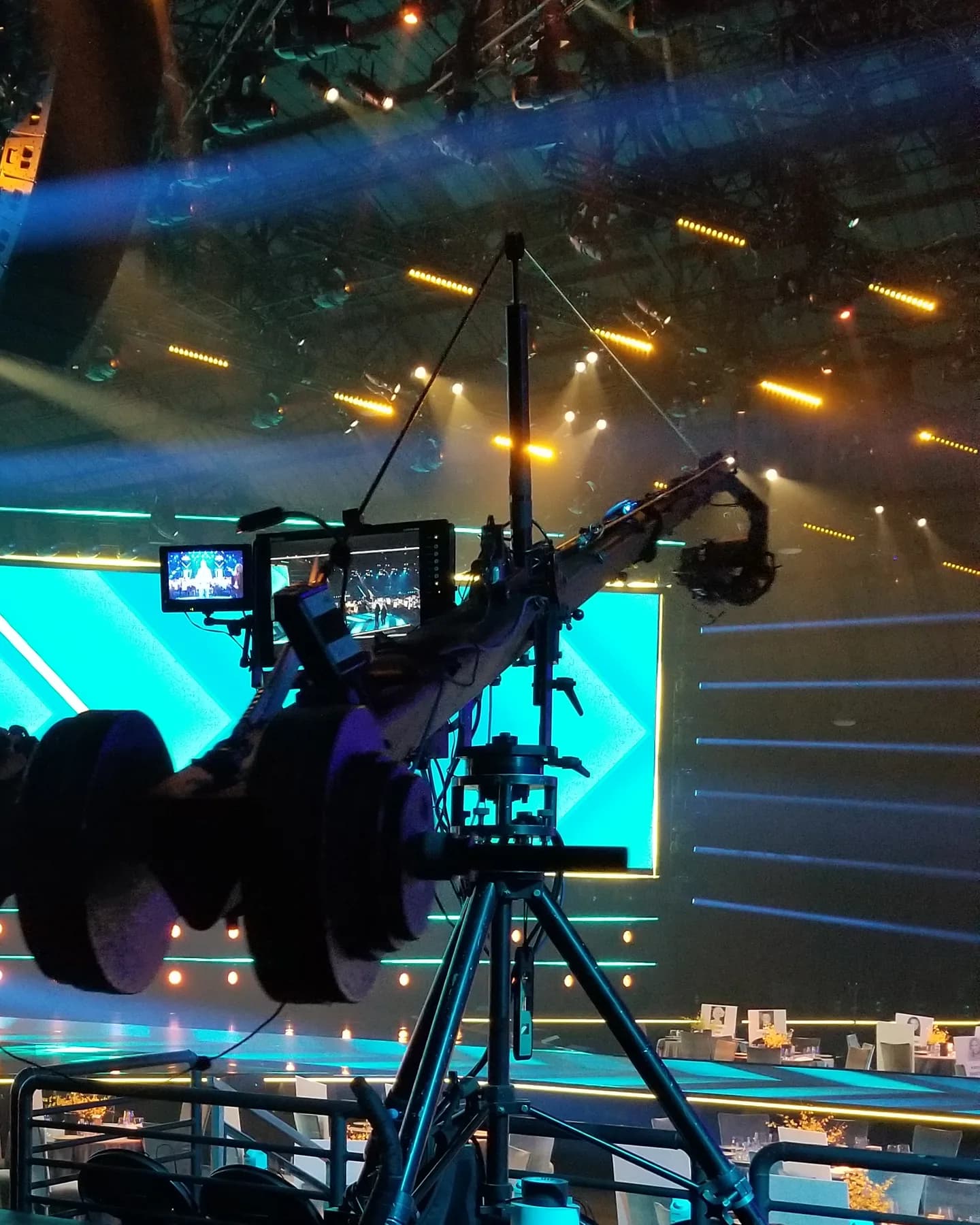 Stanton Triangle remote head on a jib arm beside the operator monitors, in front of a lit stage